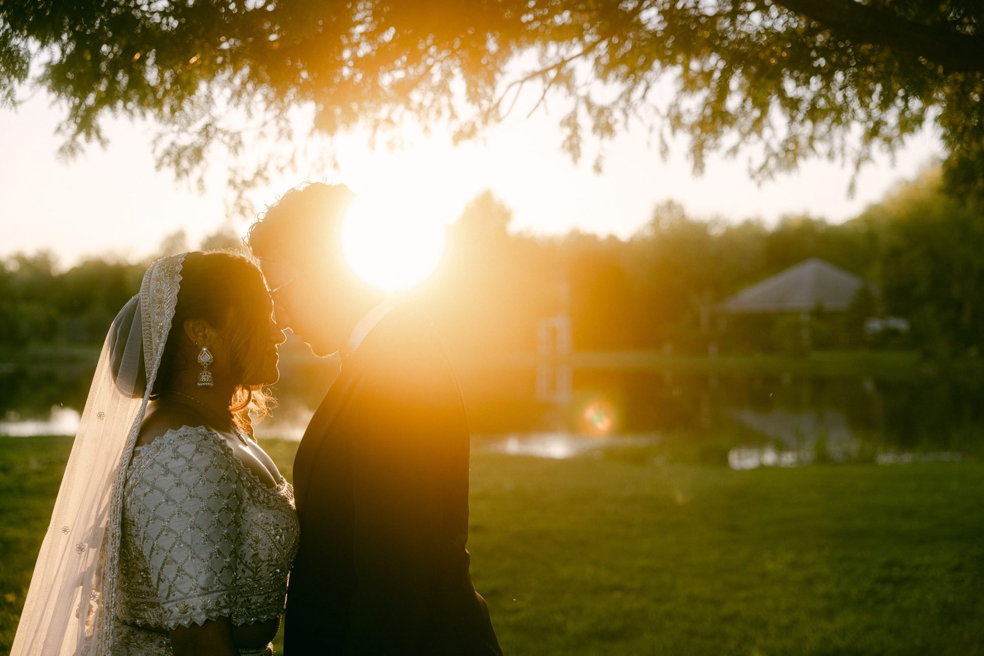 Atef and Maureen kissing at sunset with the sun between them