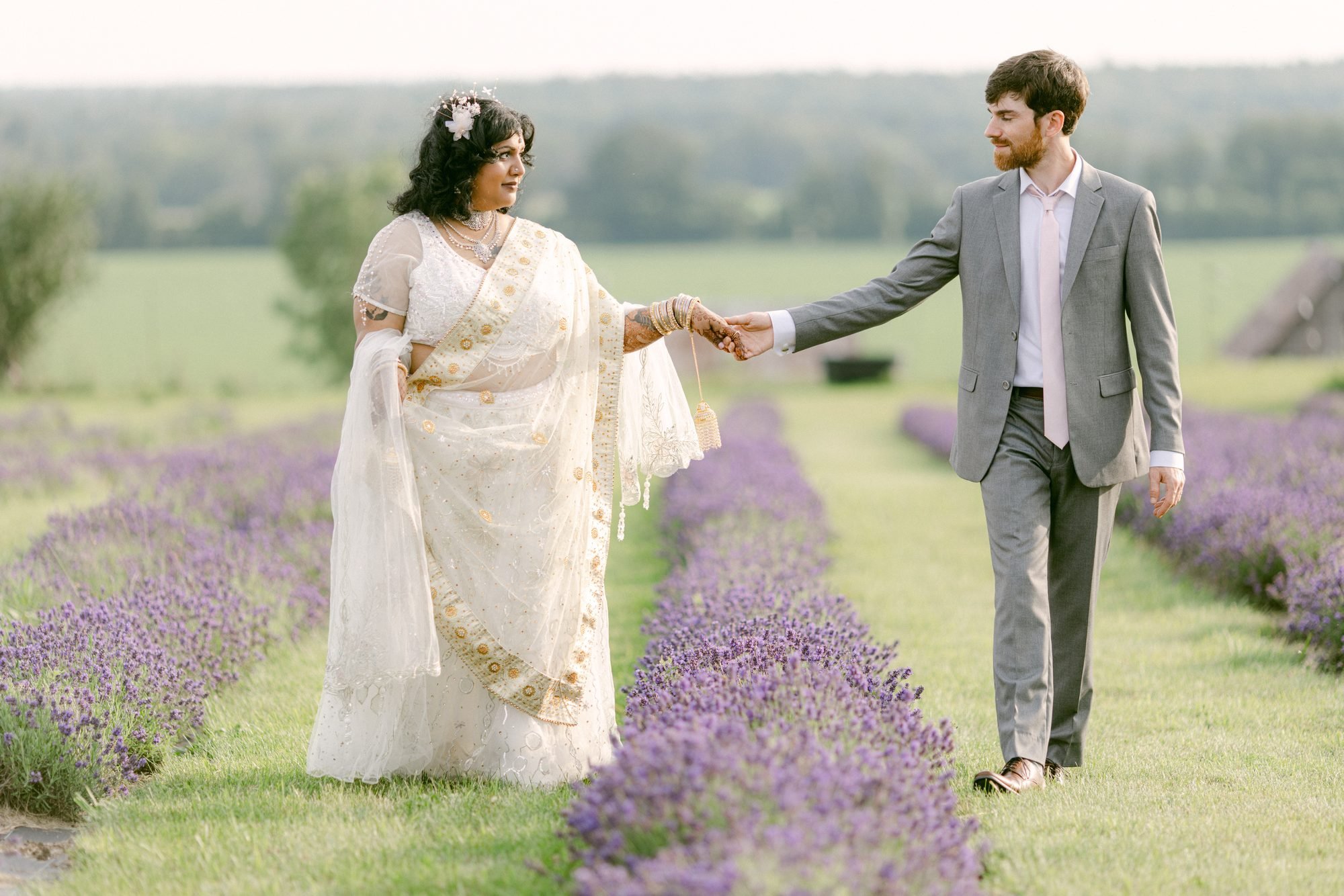 James and Munea walking hand in hand through lavender rows