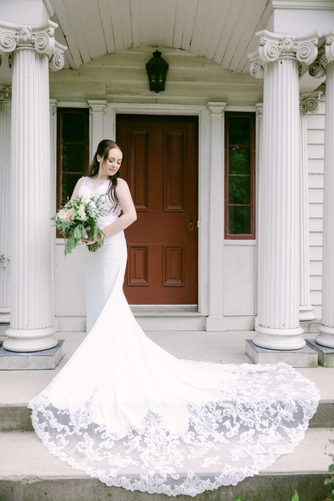Bride in a long white gown at the front doors of the venue