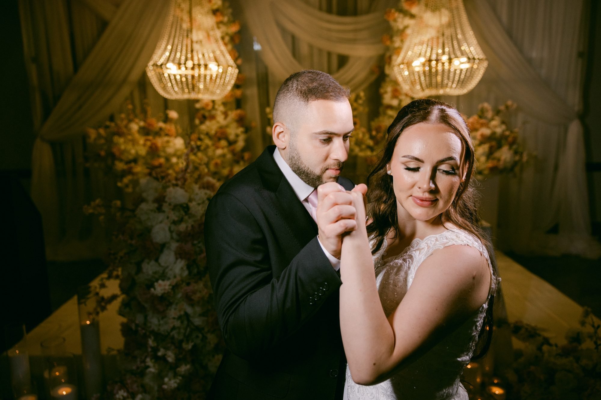 Olivia and Amro dancing close in warm golden light